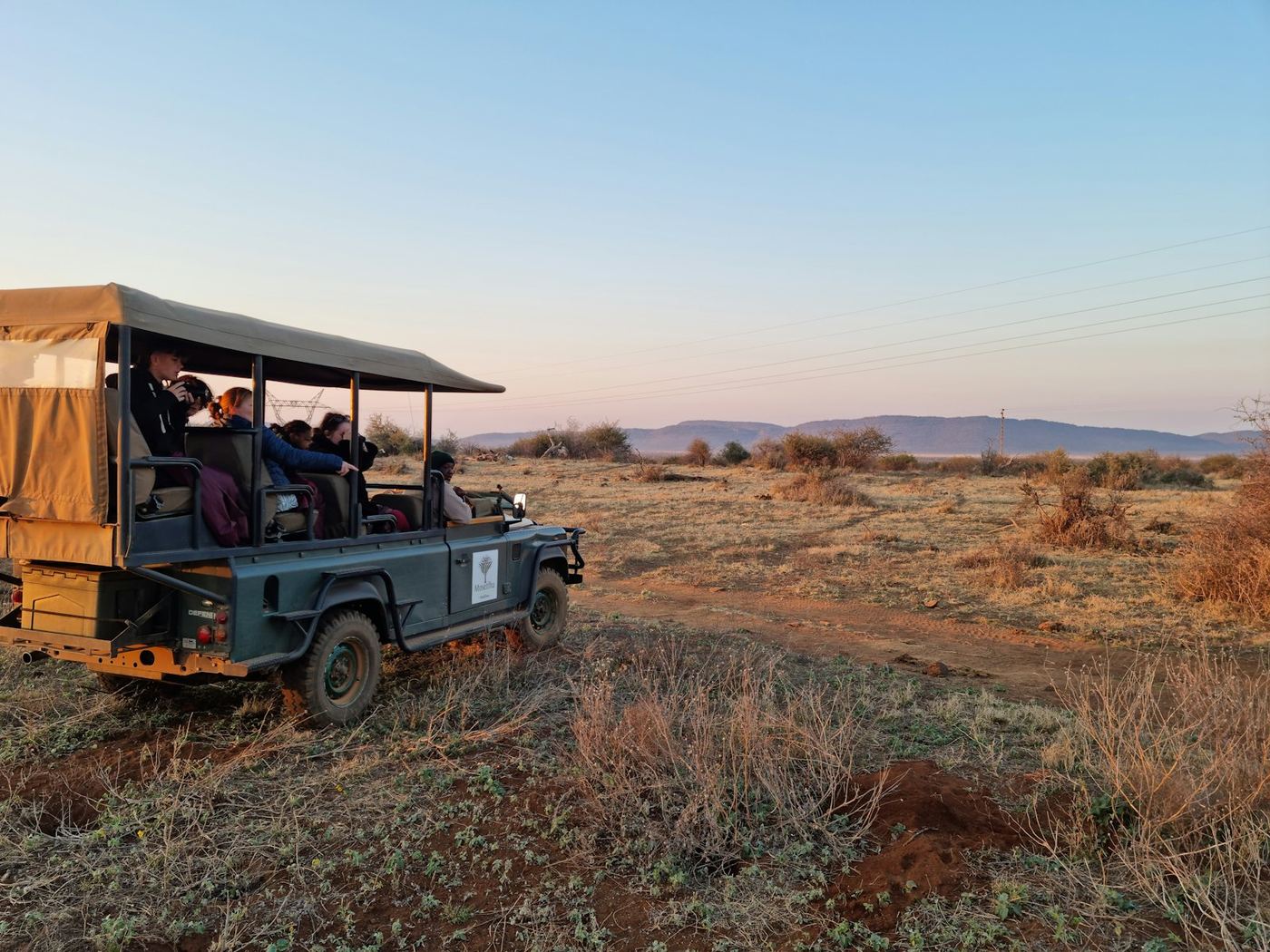 A safari vehicle at sunset